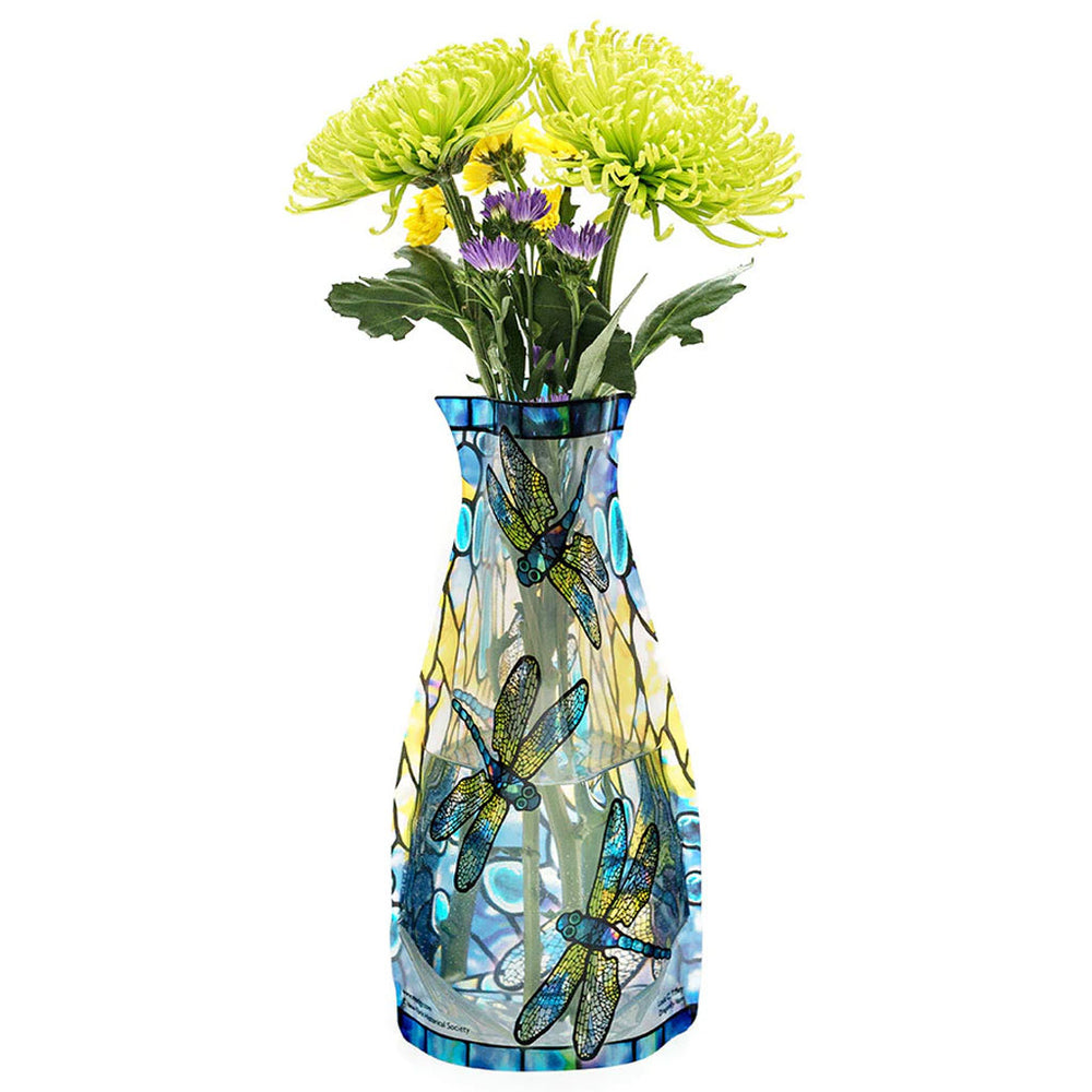 The Louis Comfort Tiffany Dragonfly Expandable Vase features a blue dragonfly design and is filled with yellow and purple flowers accented by green leaves.