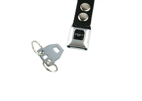 The Ford Mustang Seat Belt Key Chain features a metal seatbelt buckle, a black fabric strap with two silver studs, and a detachable key ring shaped like a seatbelt tongue.