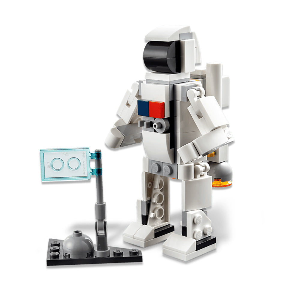 A LEGO astronaut minifigure in a white suit stands beside a compact display featuring a clear blue screen and gray dome on a black baseplate—an ideal addition for fans of the LEGO Space Shuttle or anyone creating their own custom space-themed playset.