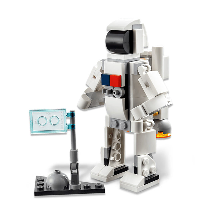 A LEGO astronaut minifigure in a white suit stands beside a compact display featuring a clear blue screen and gray dome on a black baseplate—an ideal addition for fans of the LEGO Space Shuttle or anyone creating their own custom space-themed playset.
