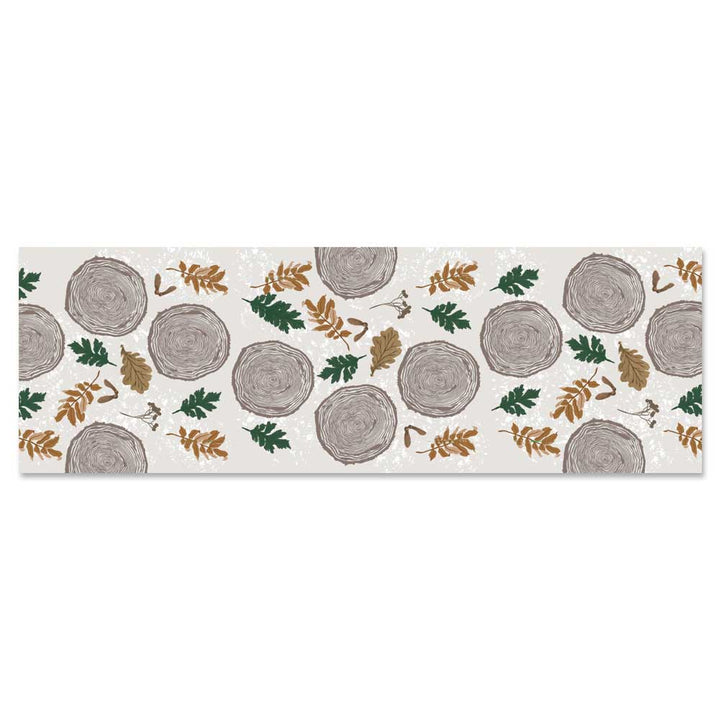 The Wood Tree Silky Scarf features a rectangular design with illustrated tree rings, green and brown leaves, and small branches on a light background—perfect as a lightweight nature-inspired accessory.