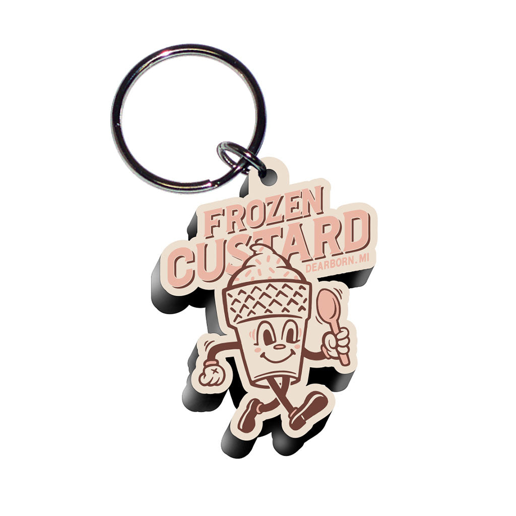 The Greenfield Village Frozen Custard Keychain features a cartoon ice cream cone with a spoon and the words "FROZEN CUSTARD" and "Dearborn, MI," making it a fun souvenir for fans of Greenfield Village.