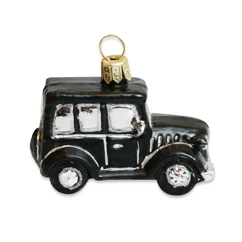 The Model T Mini Ornament is a black vintage-style blown glass ornament with silver details and a gold hanging loop, capturing the charm of Greenfield Village on a crisp white background.