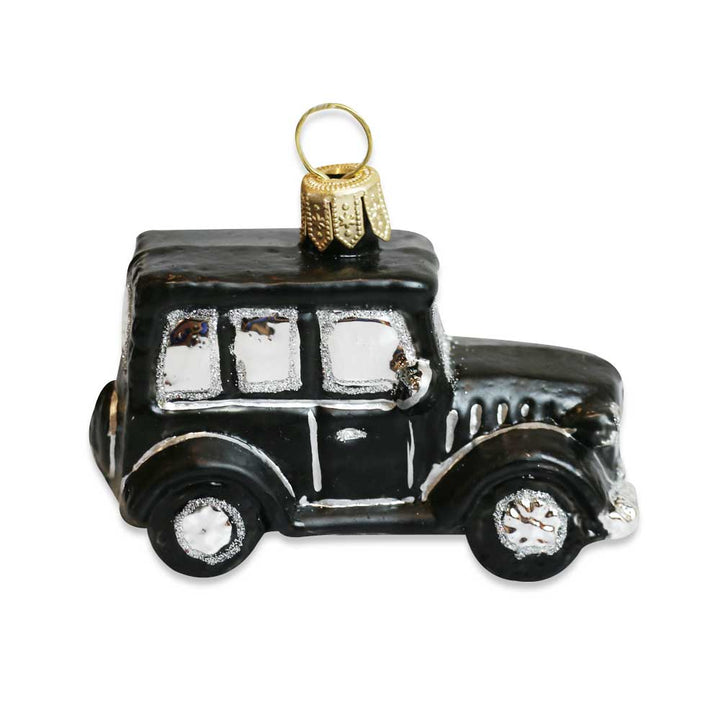 The Model T Mini Ornament is a black vintage-style blown glass ornament with silver details and a gold hanging loop, capturing the charm of Greenfield Village on a crisp white background.
