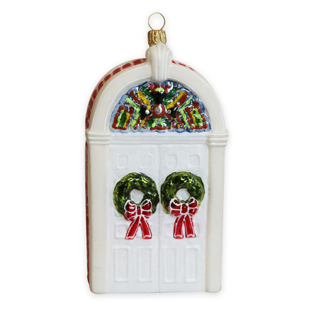 The Henry Ford Museum Festive Doors Ornament features a white door with two green wreaths adorned with red bows, a colorful fanlight window above, and a gold hanging loop—perfect for adding cheerful charm to your tree or honoring the museum.