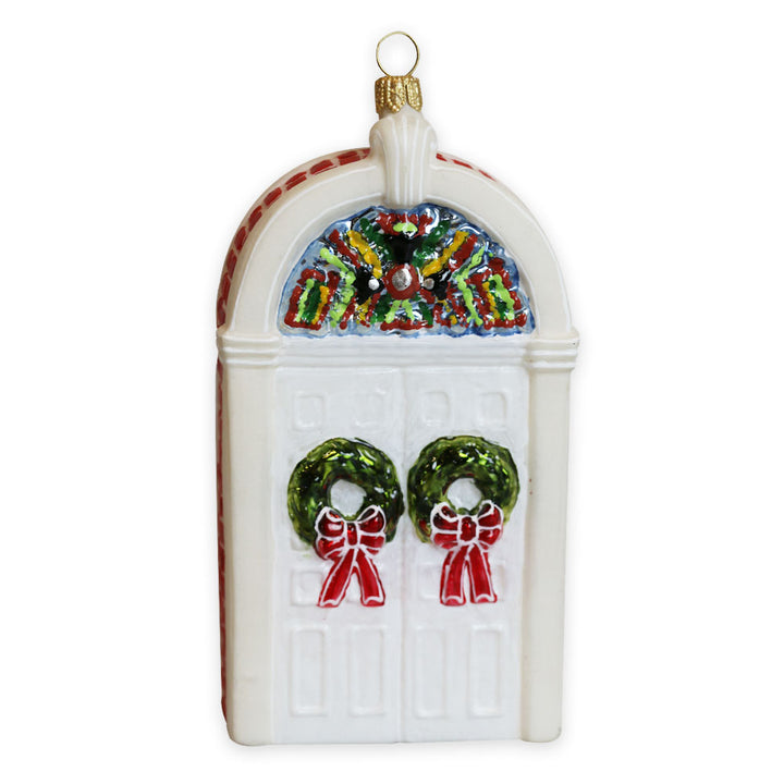 The Henry Ford Museum Festive Doors Ornament features a white door with two green wreaths adorned with red bows, a colorful fanlight window above, and a gold hanging loop—perfect for adding cheerful charm to your tree or honoring the museum.