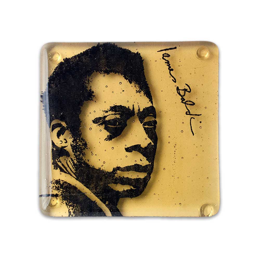 The James Baldwin Coaster features a black-and-white portrait and his signature on a golden yellow background, combining inspirational decor with a thoughtful gift.