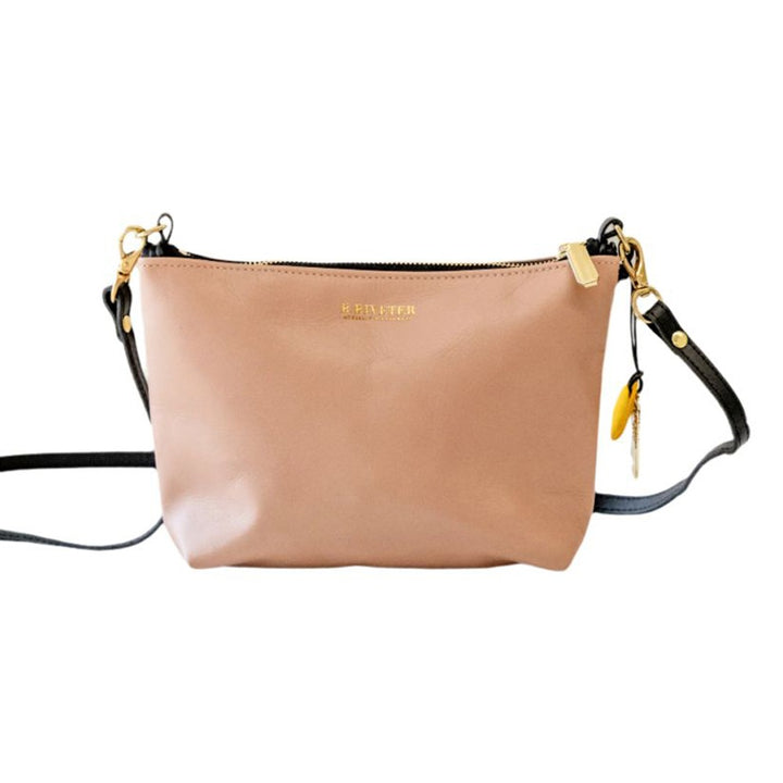 The Rosie The Riveter Leather Crossbody Bag is small and light brown, with a black adjustable strap, gold zipper and hardware, a yellow charm, subtle gold text on the front, and is proudly American assembled.