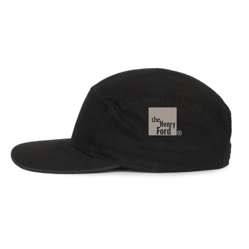 The Henry Ford® Bicycle Cap is a black five-panel cycling cap with a flat brim, featuring a beige square logo on the side that reads "The Henry Ford Museum.