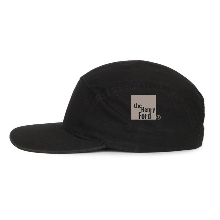 The Henry Ford® Bicycle Cap is a black five-panel cycling cap with a flat brim, featuring a beige square logo on the side that reads "The Henry Ford Museum.