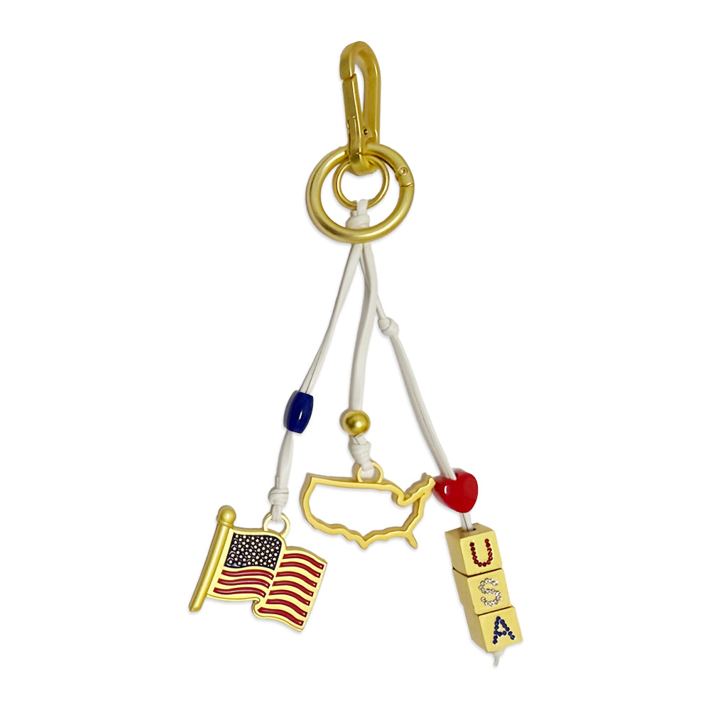 Show your love for American landmarks with the USA Icon Trio Bag Clip—a gold keychain featuring a USA map outline, American flag, and lettered blocks spelling "USA," all connected by white cords with red and blue beads.