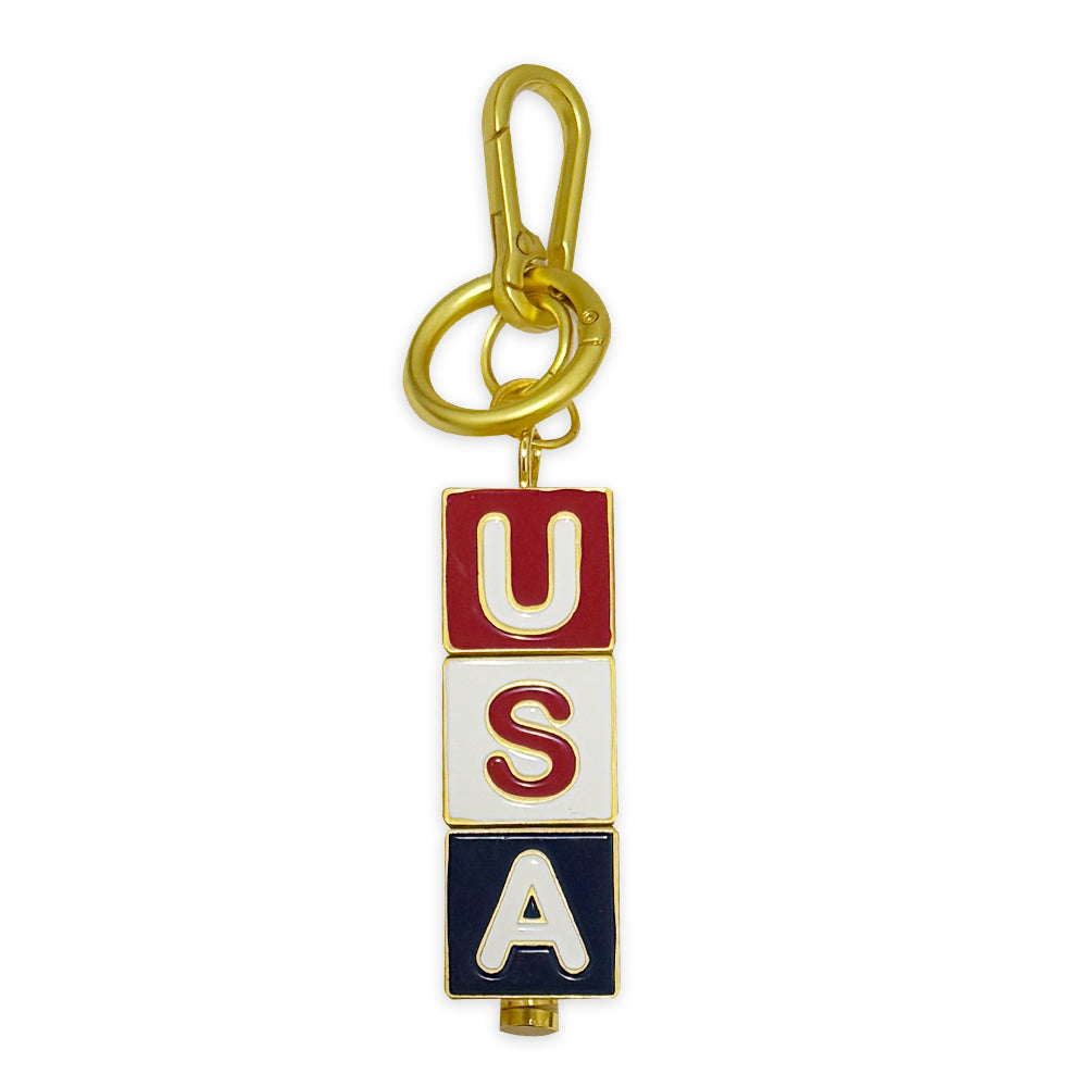 The USA Block Spinner Bag Clip is a gold keychain with three spinning blocks in red, white, and blue that spell "USA" vertically. It includes a gold bag clip and keyring at the top.