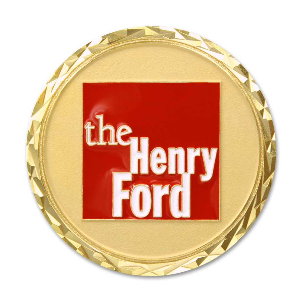 The Henry Ford® America's 250th Coin features a gold medallion with a faceted edge and a red square at the center displaying white "the Henry Ford" text—an elegant commemorative piece honoring innovation.