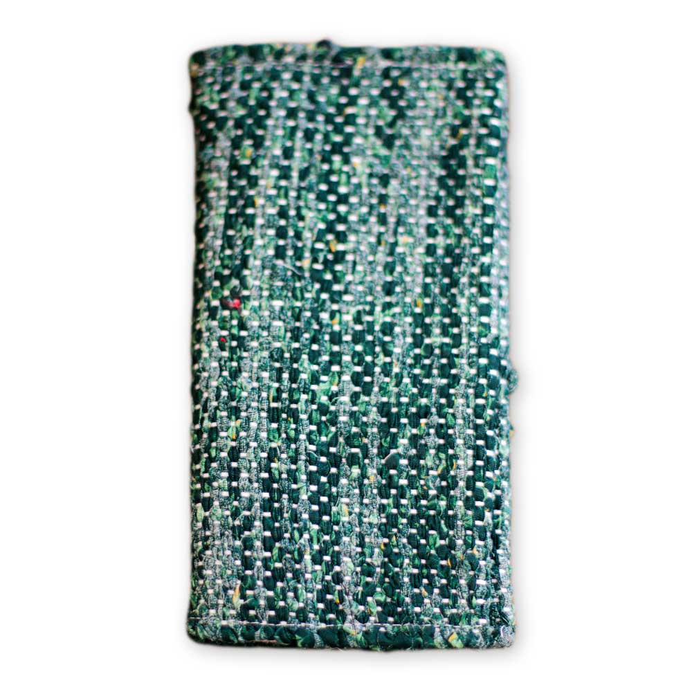 A close-up photo of the ReLoom Wallet, a rectangular green and white woven accessory with a textured surface, created through sustainable change initiatives and job training, shown on a white background.