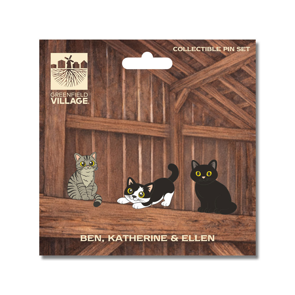 Three illustrated cats—Ben the gray tabby, Katherine the black and white, and Ellen the all black—sit on a wooden beam against a rustic barn backdrop. The text reads: Greenfield Village Barn Cats Pin Set. Collectible Pin Set featuring Ben, Katherine & Ellen.