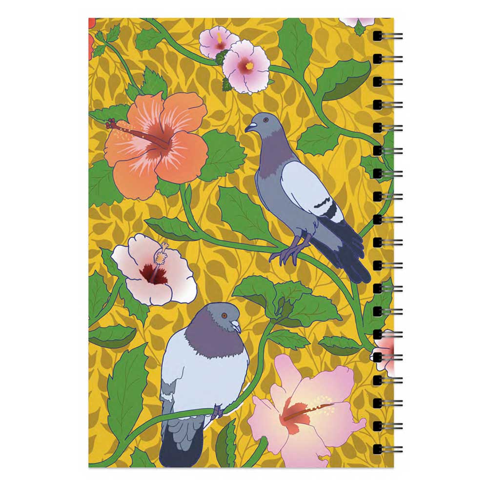The Roberto Lugo Pigeon Art Journal is spiral-bound, featuring two pigeons amid green leaves and pink hibiscus flowers on a yellow patterned cover.