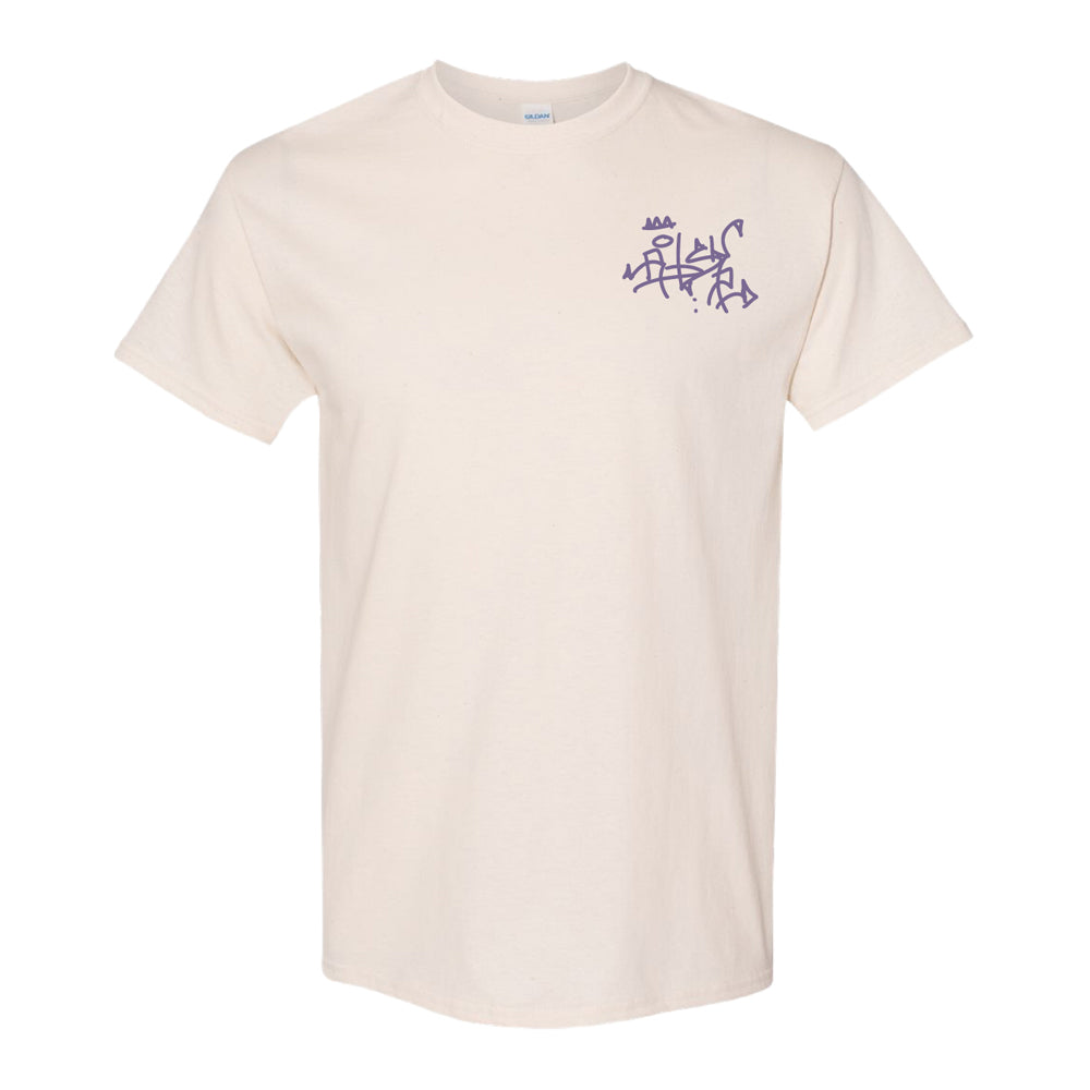 The Roberto Lugo Pleasant Pigeon T-Shirt is an off-white short-sleeve tee with abstract purple graffiti-style text on the upper left chest, shown against a plain white background.