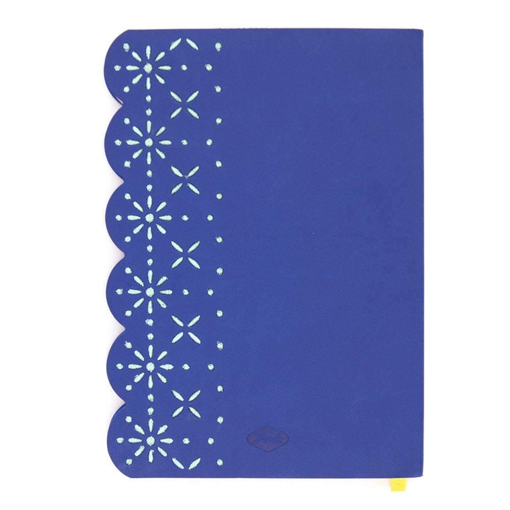 The Eyelet Embroidered Journal features blue vegan leather, a scalloped left edge with eyelet embroidery, light green stars and dots, and a small yellow ribbon bookmark for a charming touch.