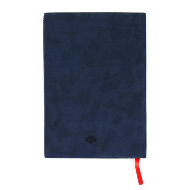 The Evelyn Blue Embroidered Journal is a closed, dark blue vegan leather notebook featuring a small black emblem on the cover and a red ribbon bookmark, displayed on a white background.