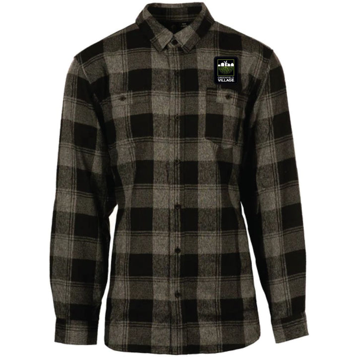 Green and gray plaid flannel button-up shirt with collar and chest pockets. A small rectangular patch featuring a logo and the word “VILLAGE” is sewn onto the left chest, adding a unique detail to the Greenfield Village Flannel T-Shirt. The shirt is displayed against a white background.
