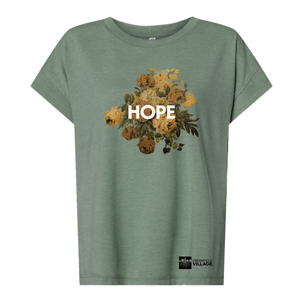 The Greenfield Village Jackson Home Hope T-Shirt is a green civil rights tee with yellow and brown flowers, "HOPE" in bold white letters, and the “GIVENANCE VILLAGE” logo at the bottom right.