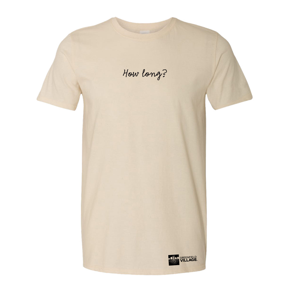 The Greenfield Village Selma How Long History T-Shirt is beige, features “How long?” in black cursive on the chest inspired by Martin Luther King Jr., and has a small Greenfield Village logo near the bottom hem.