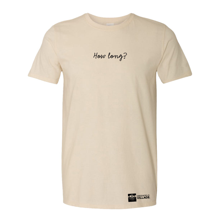 The Greenfield Village Selma How Long History T-Shirt is beige, features “How long?” in black cursive on the chest inspired by Martin Luther King Jr., and has a small Greenfield Village logo near the bottom hem.