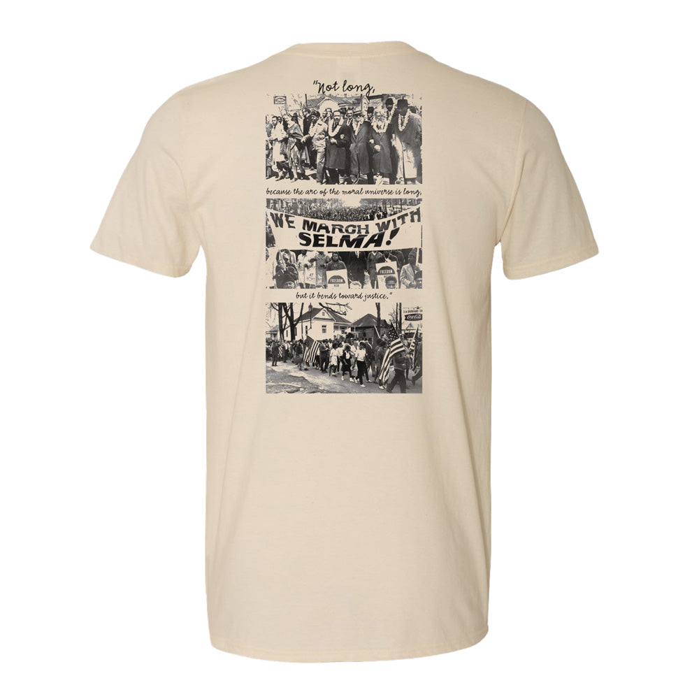 The Greenfield Village Selma How Long History T-Shirt features black-and-white images of historic civil rights marches, a WE MARCH WITH SELMA! banner, and a quote from Martin Luther King Jr.: “Not long, because the arc of the moral universe is long.”.