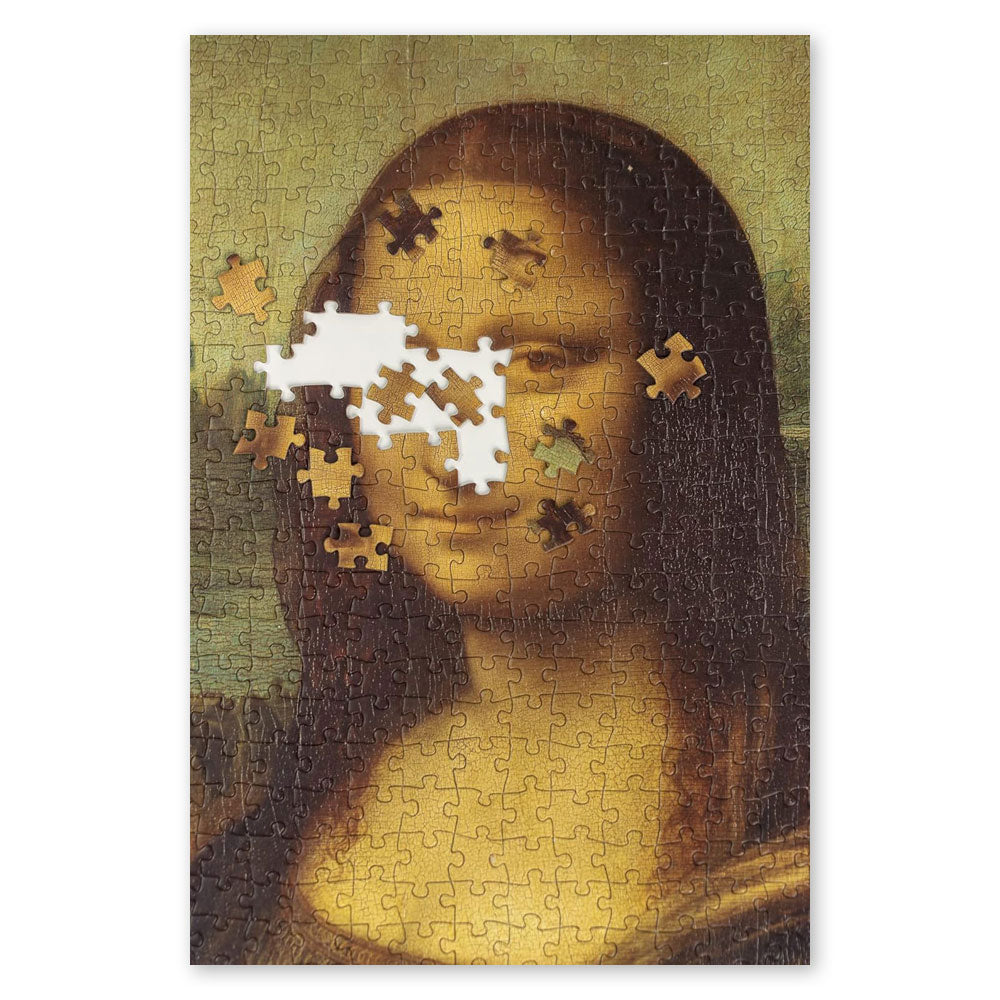 The Leonardo Da Vinci - Mona Lisa Puzzle is a 1000-piece art puzzle featuring the famous painting, with several pieces missing from Mona Lisa’s eyes and forehead and loose puzzle pieces nearby, revealing an intriguing masterpiece in progress.
