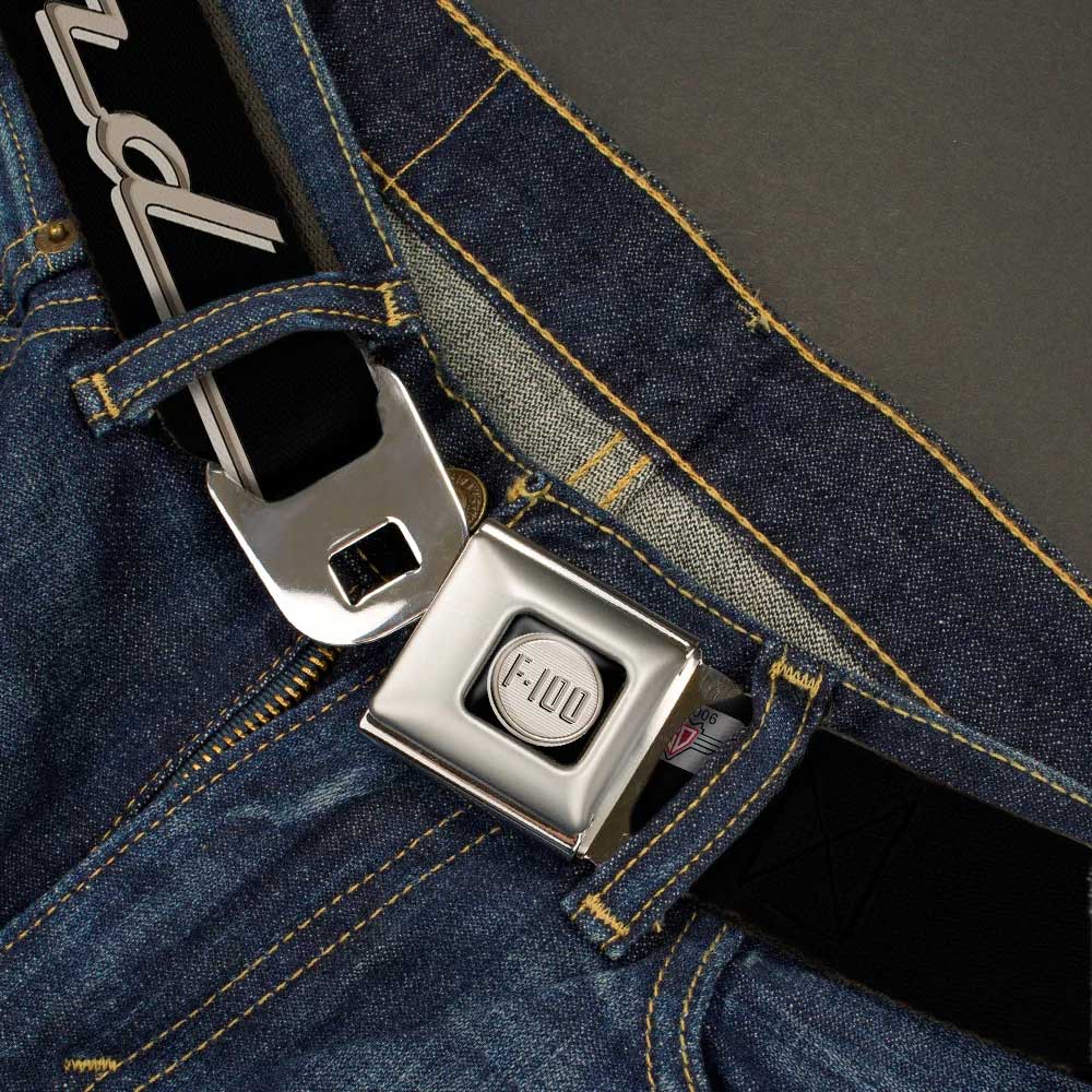 A close-up of blue jeans with the Ford F-100 Logo Seatbelt Belt, featuring an automotive buckle design and a shiny, metal airplane seat belt-style clasp.