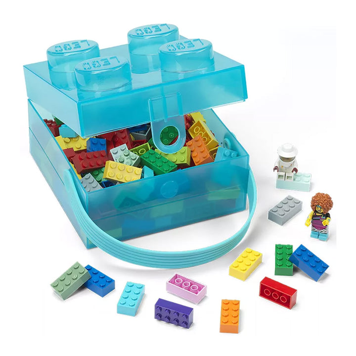 The LEGO Translucent Light Blue Storage Box, designed to look like a classic LEGO brick, is open to reveal an assortment of colorful LEGO pieces inside. Ideal for kids’ organization, additional bricks, a minifigure, and a small build are displayed outside the box.