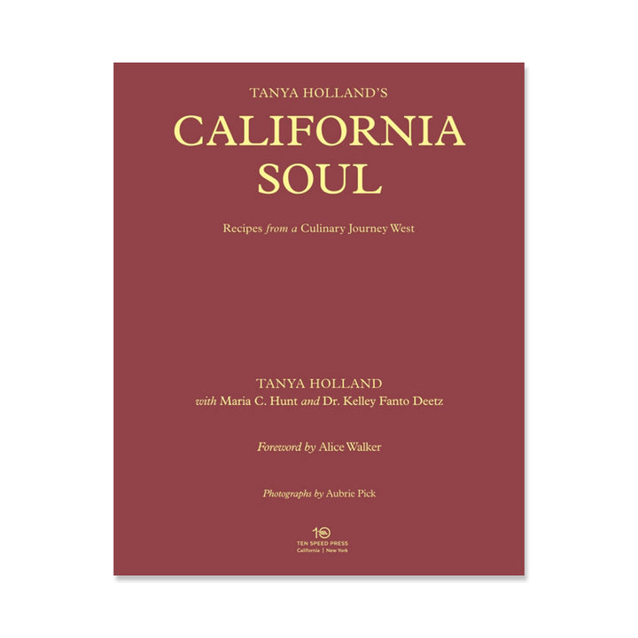 A maroon book cover with gold text displays the title, “Tanya Holland’s California Soul: Recipes from a Culinary Journey West,” along with author and contributor names. The publisher’s logo appears at the bottom.