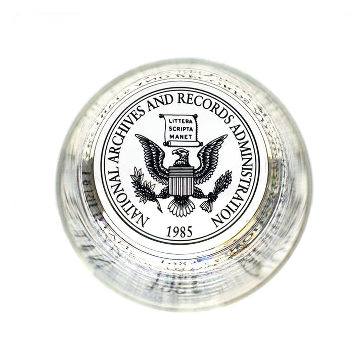 A glass paperweight featuring the National Archives seal with an eagle, shield, "Littera Scripta Manet," and 1985—an ideal match for your U.S. Constitution Rocks Glass collection.