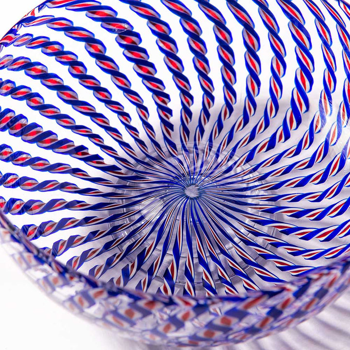 A close-up of the 2026 Candy Cane Bowl, expertly crafted by glassblowers, showcases swirling blue and red twisted stripes forming a mesmerizing spiral that converges at the bowl’s center.