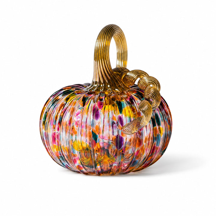 The Small Glass Pumpkin - Kaleidoscope is a vibrant, ribbed hand-blown glass pumpkin with a golden stem and curly vine, adorned with splashes of red, yellow, blue, and green on a white background—an exquisite collectible keepsake reminiscent of the artistry found at Greenfield Village.
