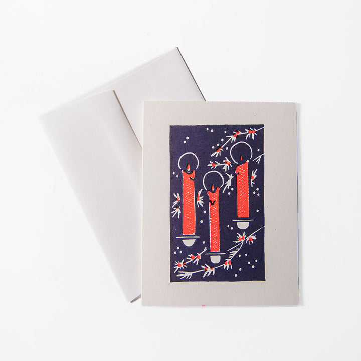The 2026 Candy Cane Card Set features a handprinted holiday card with three lit red candles surrounded by white and red branches on a dark background, paired with a white envelope.