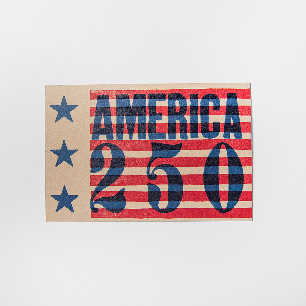 The America 250 Postcard is printed on brown kraft paper with red and white stripes, three blue stars on the left, and bold blue "AMERICA 250" text, commemorating America's 250th anniversary.