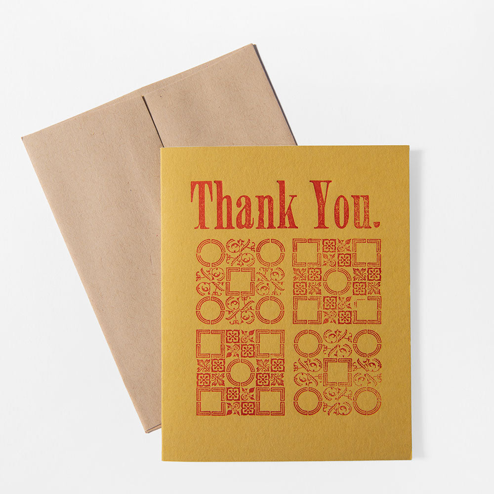 A set of 6 yellow handmade thank you cards featuring red decorative patterns and bold "Thank You." text, shown atop a brown envelope against a white background.