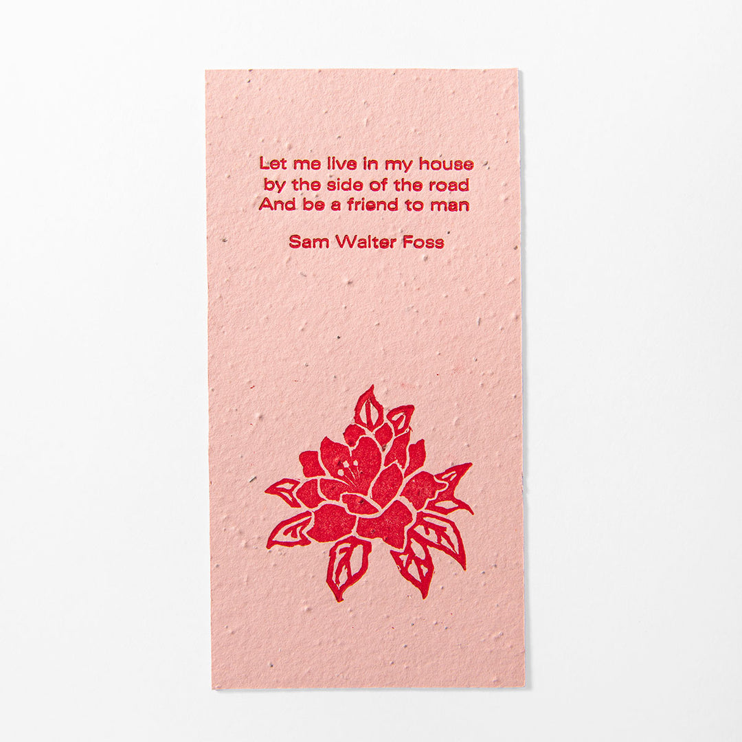 A pink rectangular "House by the Side of the Road" seeded paper bookmark featuring a red floral illustration and an inspirational excerpt by Sam Walter Foss in red text. The card has a textured, speckled surface and is displayed against a white background.