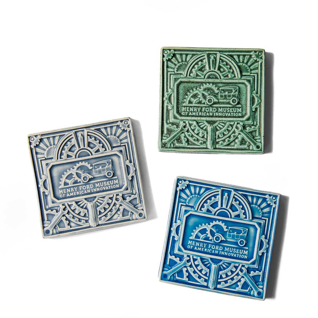 Featuring intricate designs with the Henry Ford Museum of American Innovation text and a car-and-gears motif, The Henry Ford® Art Tile comes in three square handcrafted ceramic styles—green, light gray, and blue. These tiles make for striking museum-quality decor in any space.
