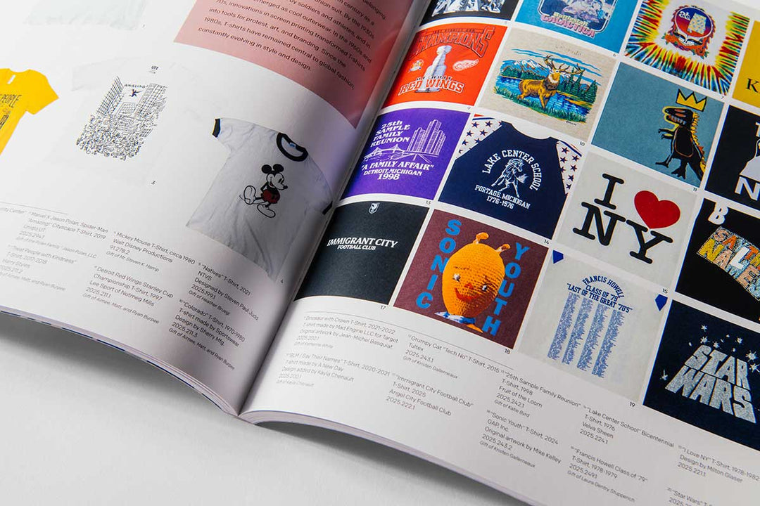 The open magazine displays a vibrant array of graphic T-shirt designs—featuring iconic logos, illustrations, and text such as I ♥ NY and Star Wars—each accompanied by descriptive captions that showcase how these shirts have become contemporary American artifacts, as highlighted in The Henry Ford’s Fabric of America and Handmade Exhibition Catalog.