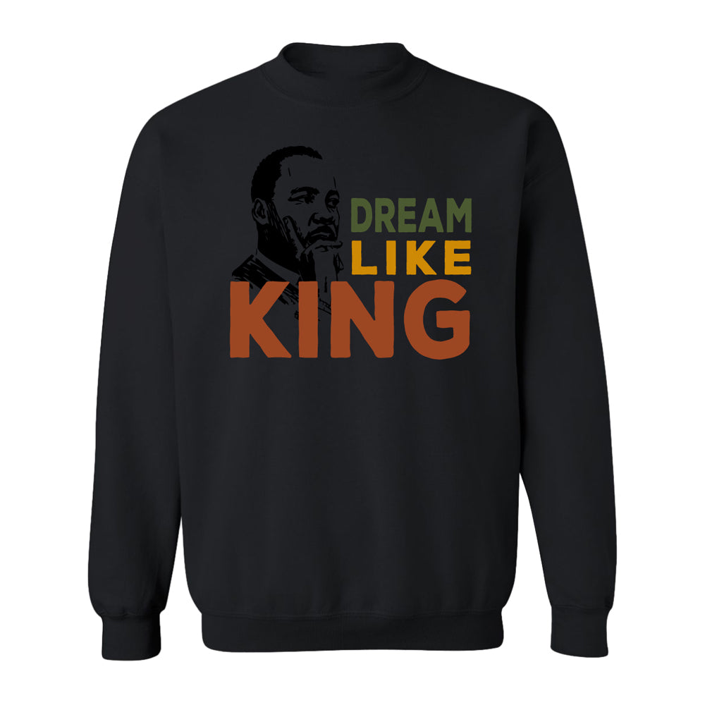The Henry Ford® Dream Like King Fleece Crew Sweatshirt is a black crewneck featuring an illustrated Martin Luther King Jr. portrait with "DREAM LIKE KING" in bold green, yellow, and orange letters across the front.