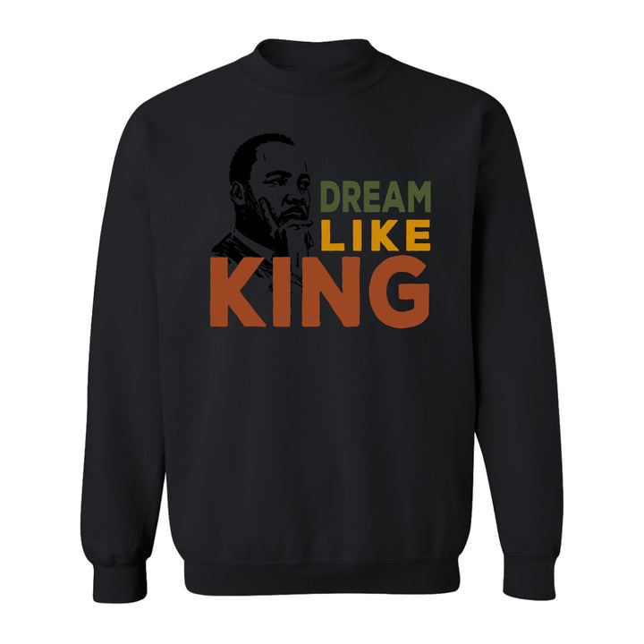 The Henry Ford® Dream Like King Fleece Crew Sweatshirt is a black crewneck featuring an illustrated Martin Luther King Jr. portrait with "DREAM LIKE KING" in bold green, yellow, and orange letters across the front.