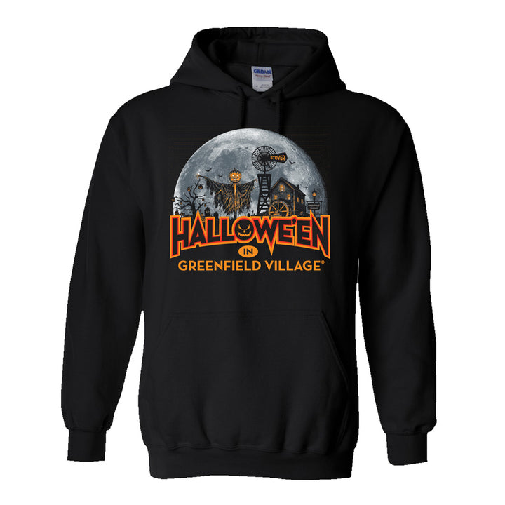 The Henry Ford® Greenfield Village Halloween Glow Hooded Sweatshirt features a black base adorned with a large moon, spooky scarecrow, and other Halloween-themed images. The front displays “HALLOWEEN IN GREENFIELD VILLAGE” in bold orange letters, making it the perfect festive sweatshirt for creating lasting memories during your visit to Greenfield Village.