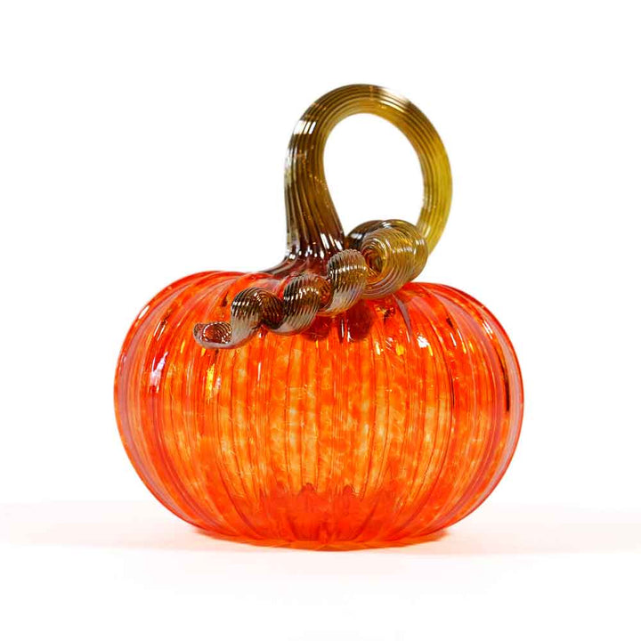 Introducing the Small Glass Pumpkin - Orange: a shiny, hand-blown glass pumpkin featuring a vibrant orange color, ribbed texture, and a curly brown glass stem on top. This collectible keepsake evokes the charm of Greenfield Village and is beautifully showcased against a pristine white background.