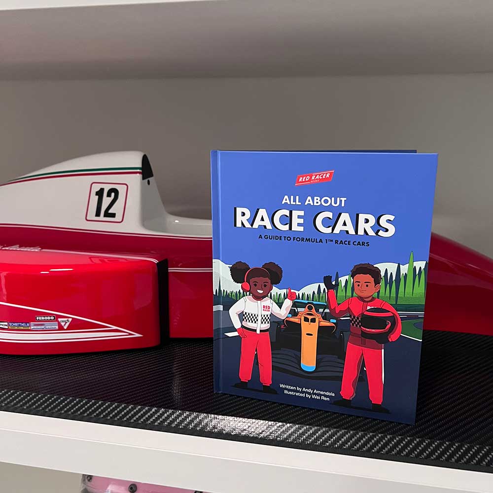 The children’s book "All About Race Cars - A Guide to Formula 1 Race Cars" stands upright on a shelf next to a red and white toy Formula 1 car with the number 12. The cover shows two kids in racing gear sharing STEM facts for kids.