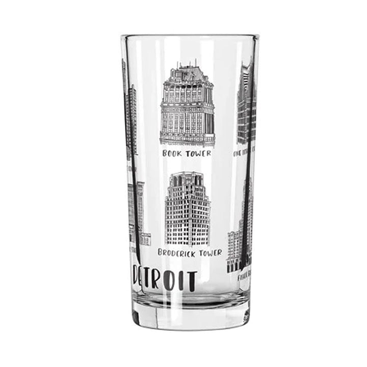 The Buildings of Detroit 12oz Glass from City Bird features black-and-white illustrations of iconic Detroit buildings, including Book Tower and Broderick Tower, with "Detroit" printed near the base.