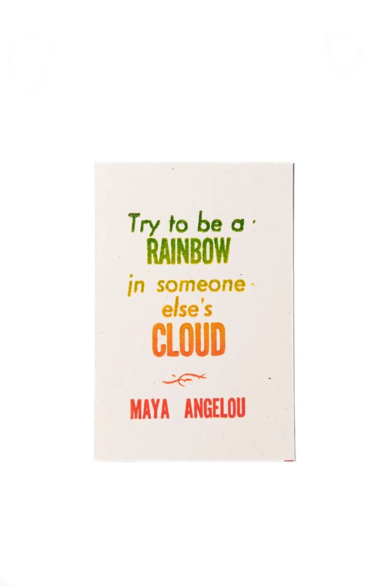 The Angelou Quote Postcard features "Try to be a rainbow in someone else's cloud," with 'rainbow' and 'cloud' in colorful gradient, printed via rainbow roll on crisp French Paper Speckletone. White background.
