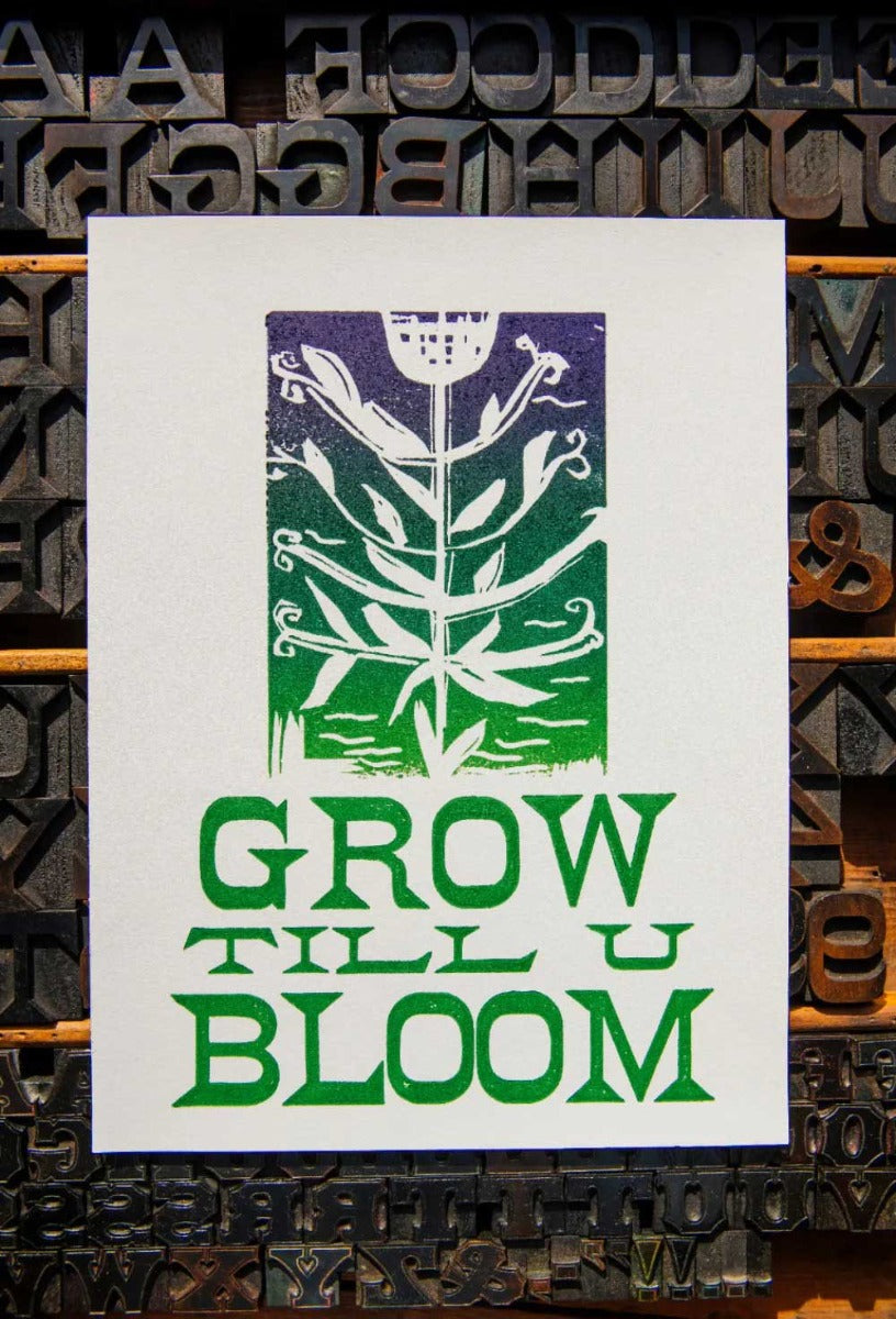 The Grow Till U Bloom Poster features a stylized green and purple floral lino-cut above the phrase "GROW TILL U BLOOM," set against a background of assorted letterpress type blocks on soft cotton fiber paper.