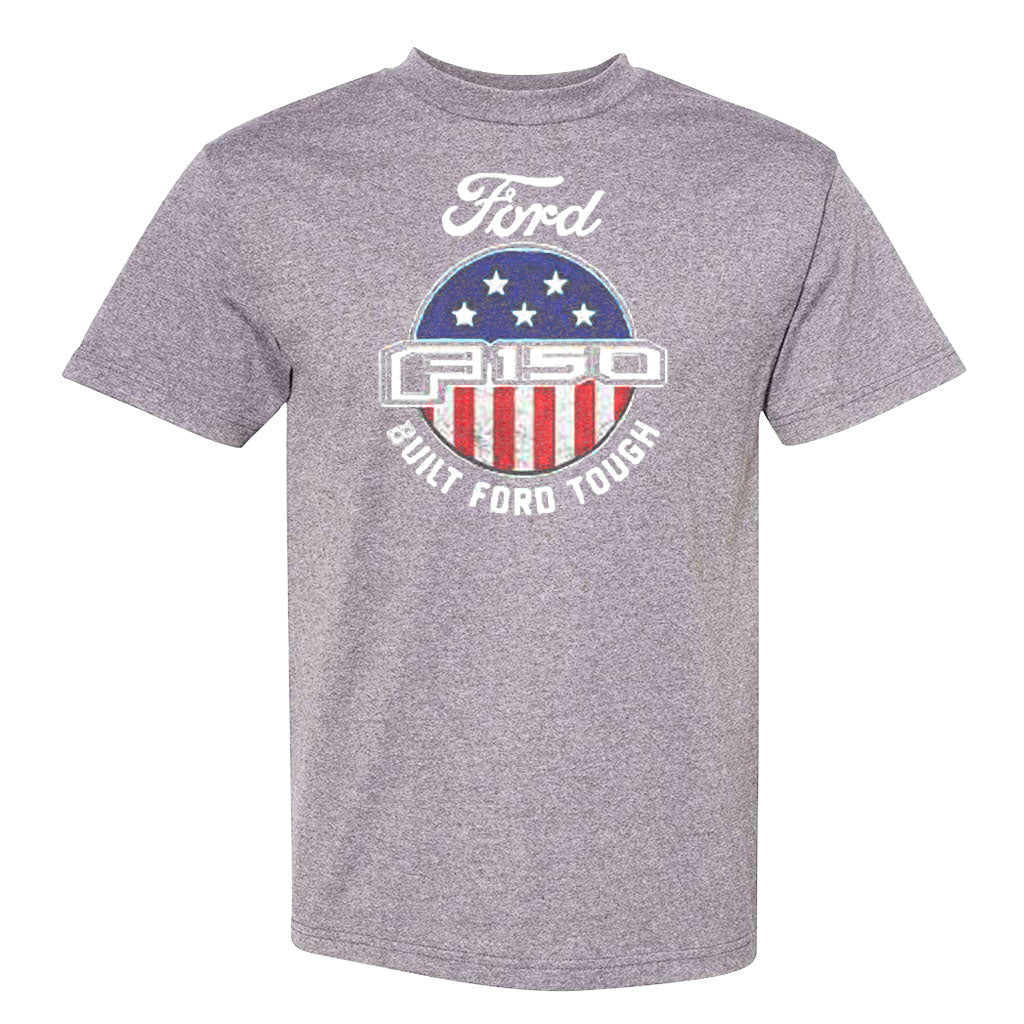 The Ford F150 T-Shirt is a gray tee with a stylized Ford logo, Built Ford Tough text, and a circular American flag emblem. Officially licensed merchandise for real Ford fans.